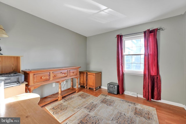 bedroom with baseboards, visible vents, and wood finished floors