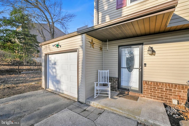 property entrance featuring a garage and brick siding