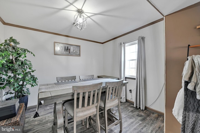 dining room featuring an inviting chandelier, baseboards, crown molding, and wood finished floors