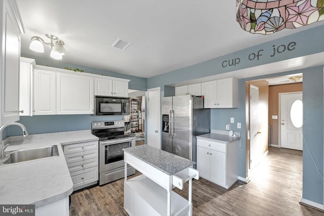 kitchen featuring light countertops, visible vents, appliances with stainless steel finishes, white cabinets, and a sink