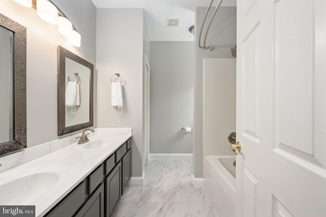 full bath featuring marble finish floor, a sink, baseboards, and double vanity