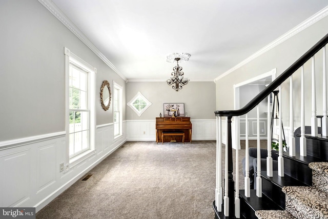 interior space with a chandelier, visible vents, stairs, wainscoting, and carpet