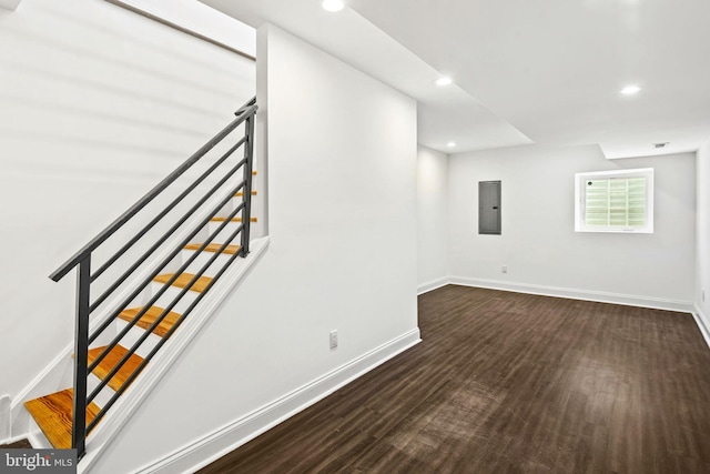 interior space featuring stairway, electric panel, baseboards, and wood finished floors