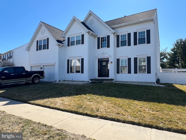 view of front of house with a garage, fence, and a front lawn