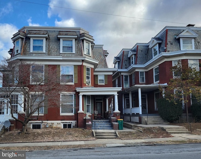 second empire-style home with mansard roof and brick siding