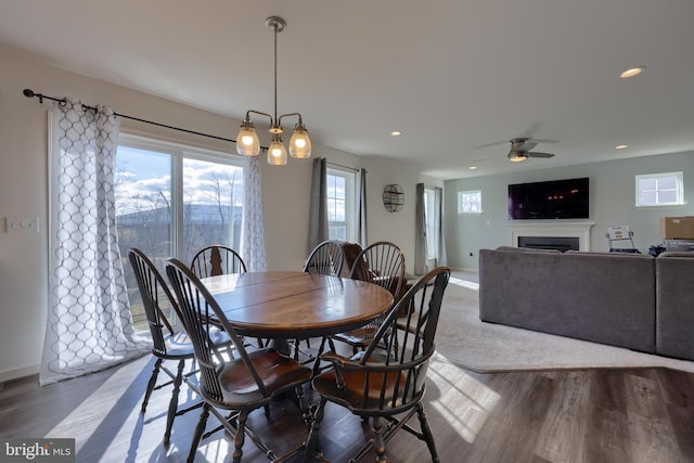 dining area featuring a fireplace, baseboards, wood finished floors, and recessed lighting