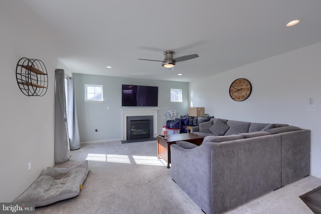 living room with a fireplace with flush hearth, recessed lighting, light colored carpet, and a ceiling fan