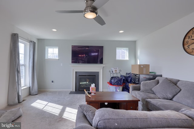 carpeted living room featuring a fireplace with flush hearth, recessed lighting, ceiling fan, and baseboards