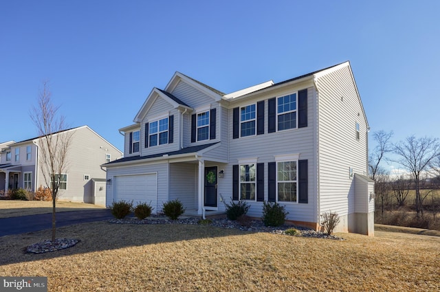 view of front of home featuring an attached garage, aphalt driveway, and a front yard