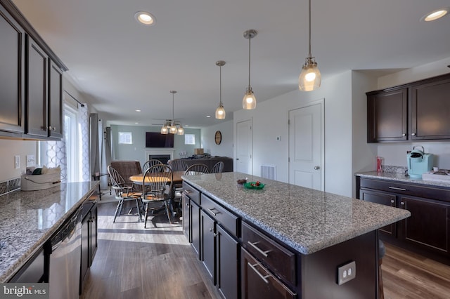 kitchen featuring dark wood-style floors, open floor plan, dark brown cabinets, and stainless steel dishwasher