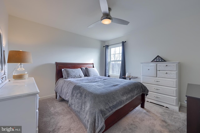 bedroom with ceiling fan, baseboards, and light colored carpet