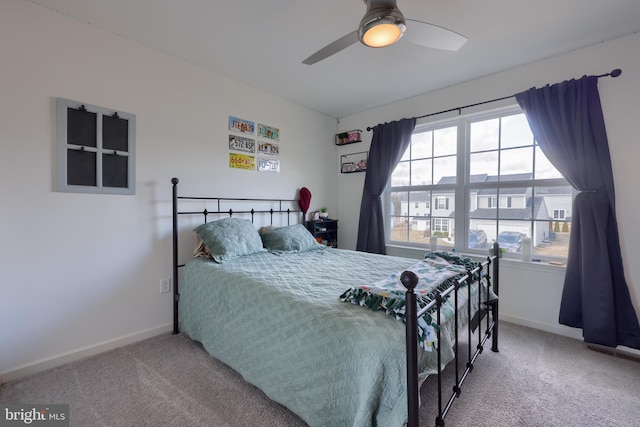 carpeted bedroom with ceiling fan and baseboards