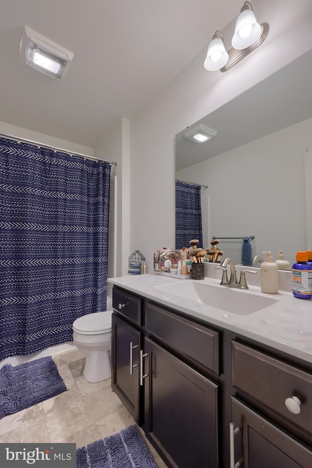 bathroom featuring toilet, vanity, and visible vents