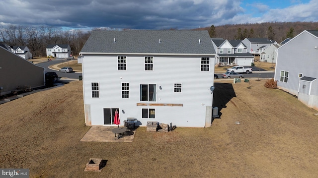 rear view of property featuring a patio area, a residential view, and a lawn