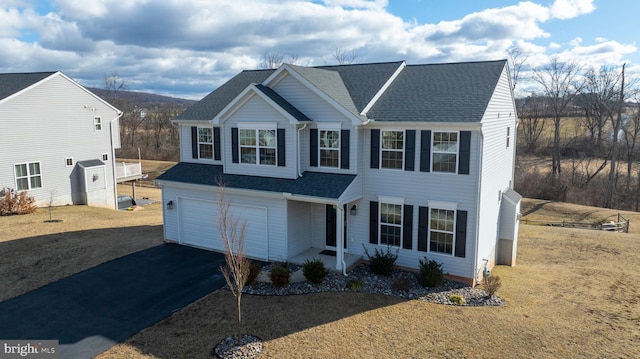 view of front of house with aphalt driveway, an attached garage, and a shingled roof