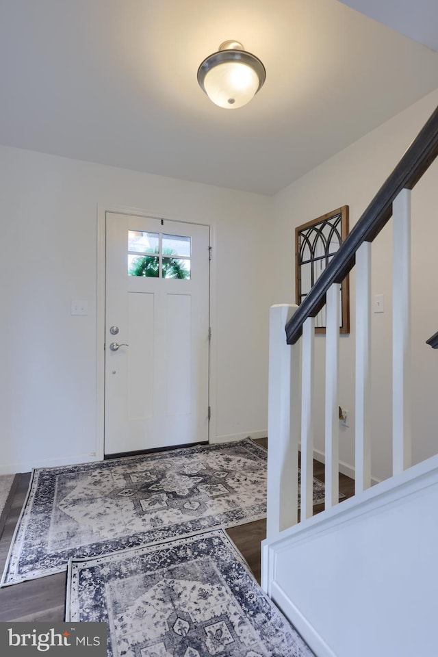 foyer entrance featuring stairway and wood finished floors