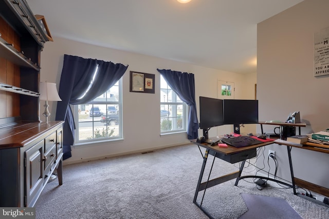 carpeted office space featuring visible vents and baseboards