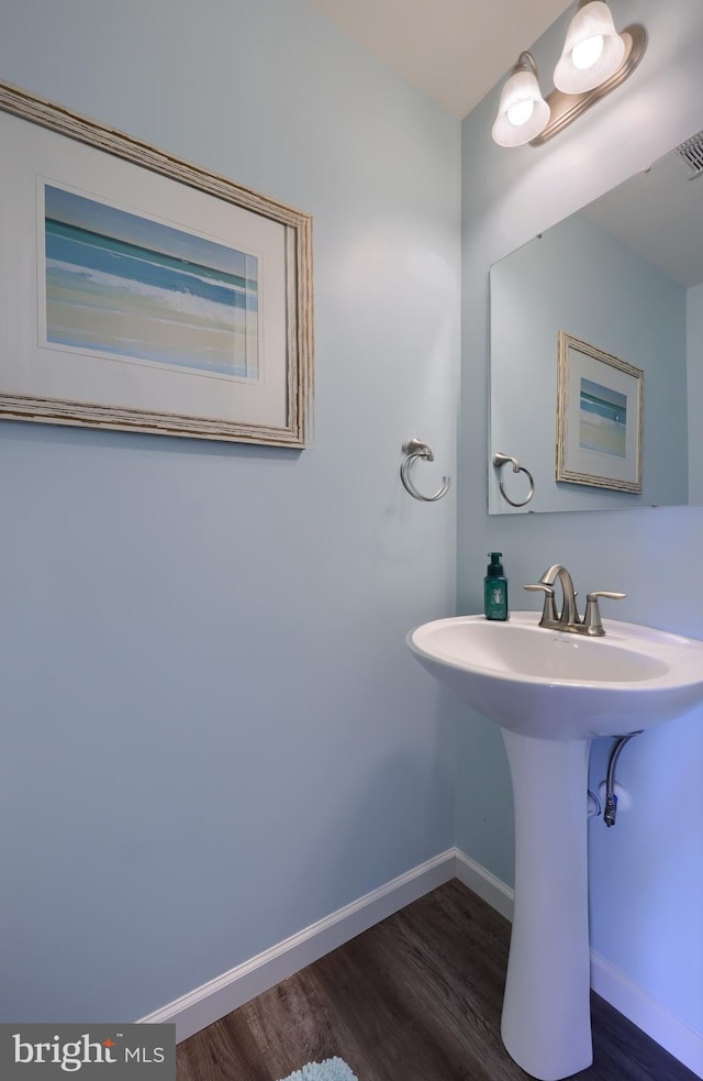 bathroom with a sink, baseboards, and wood finished floors