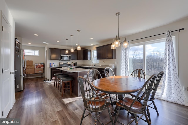 dining space with dark wood-type flooring, a wealth of natural light, and recessed lighting