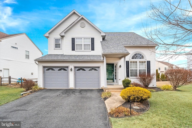 view of front of house featuring an attached garage, a shingled roof, fence, driveway, and a front lawn