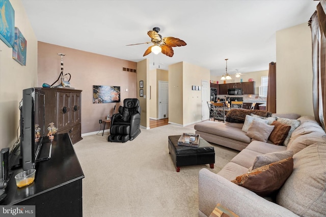 living room with light carpet, ceiling fan, visible vents, and baseboards