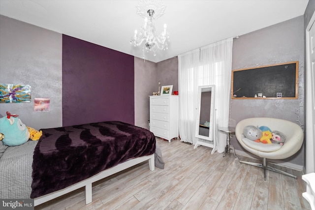 bedroom with a notable chandelier and wood finished floors