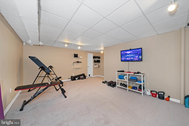 exercise room with carpet, a drop ceiling, and baseboards