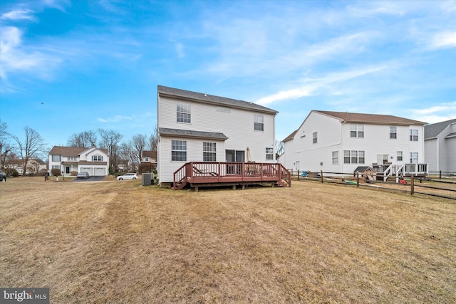 rear view of house with a yard, central AC unit, fence, a residential view, and a wooden deck