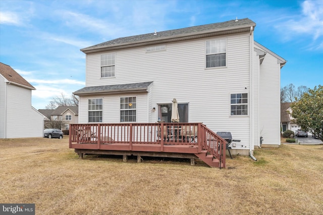 back of property with a deck and a lawn