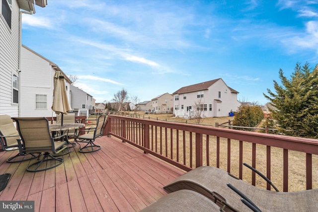 wooden terrace with outdoor dining area and a residential view