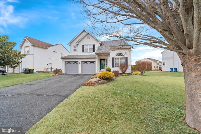 traditional home featuring driveway, a front lawn, an attached garage, and a shingled roof