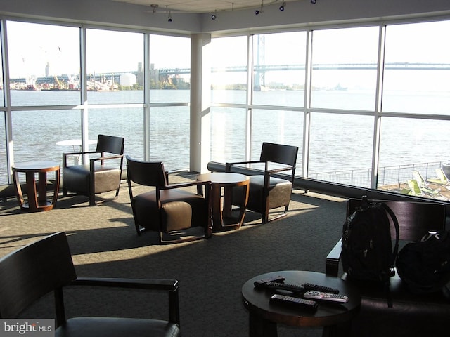 interior space with rail lighting and a water view