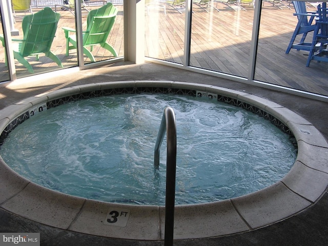 view of pool featuring a deck and a hot tub