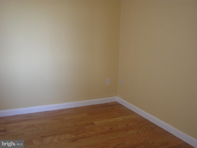 unfurnished room featuring baseboards and light wood finished floors