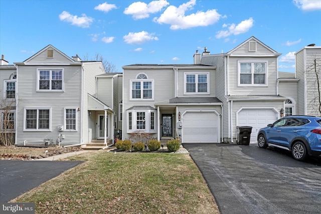 townhome / multi-family property featuring driveway, a garage, a chimney, and a front yard