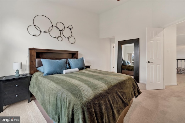 bedroom featuring light carpet and baseboards