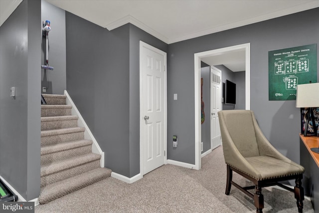 sitting room with carpet floors, ornamental molding, baseboards, and stairs