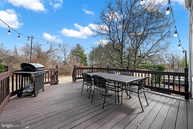 deck with outdoor dining space and grilling area