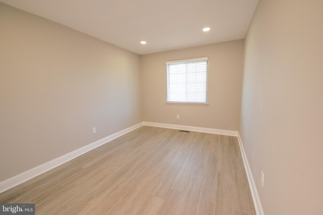 unfurnished room featuring light wood-style floors, recessed lighting, visible vents, and baseboards