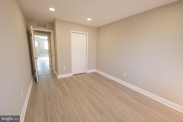 unfurnished bedroom with recessed lighting, visible vents, baseboards, light wood-style floors, and a closet