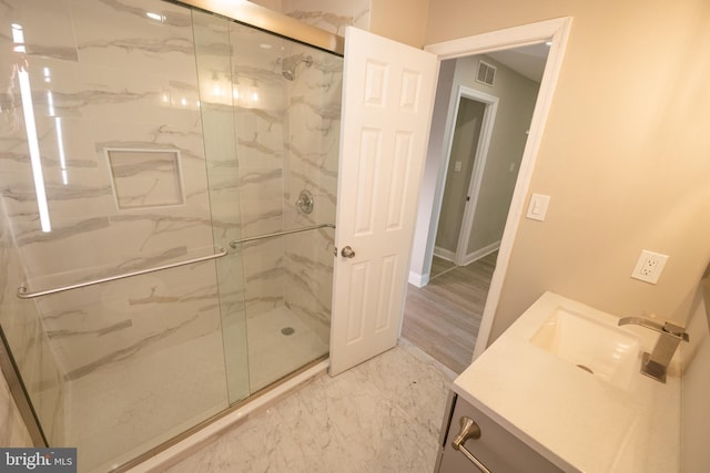 full bath with a marble finish shower, baseboards, visible vents, marble finish floor, and vanity