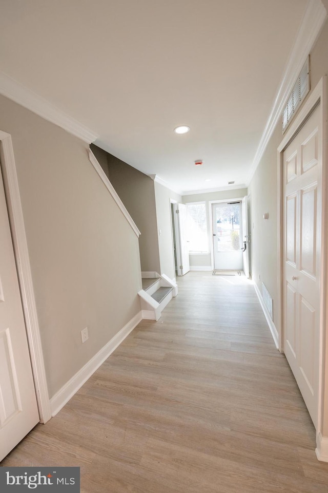 corridor featuring light wood-style flooring, stairway, and ornamental molding