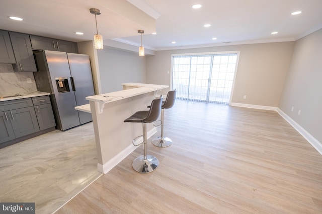 kitchen featuring ornamental molding, backsplash, stainless steel fridge, and gray cabinets