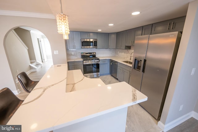 kitchen featuring light stone counters, recessed lighting, stainless steel appliances, decorative backsplash, and decorative light fixtures