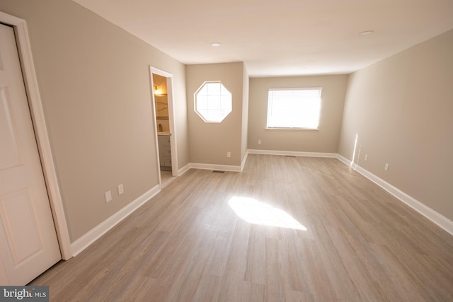 interior space featuring visible vents, light wood-style flooring, and baseboards