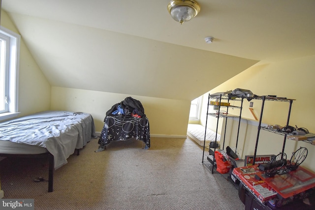 bedroom featuring lofted ceiling, baseboards, and carpet flooring