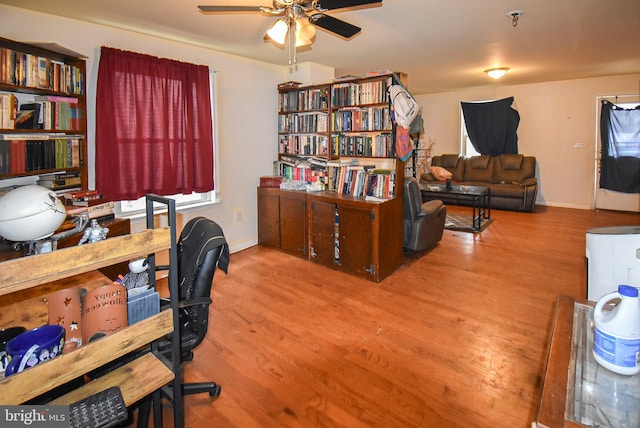 office space with a ceiling fan, baseboards, and wood finished floors