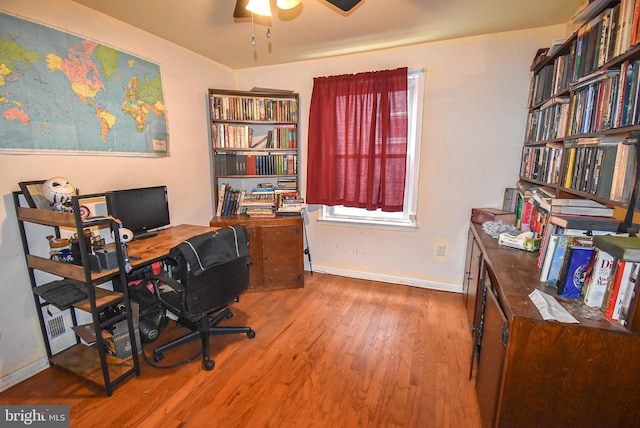 home office featuring a ceiling fan, baseboards, and wood finished floors