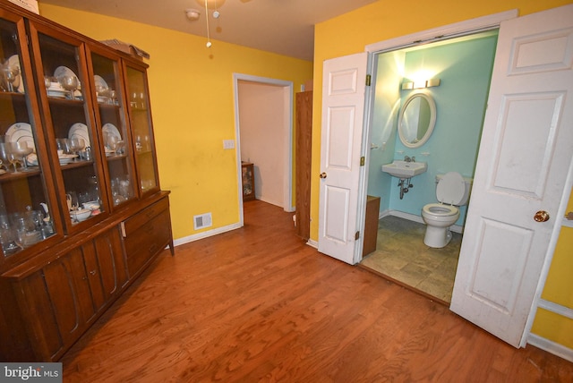 interior space with light wood-type flooring, visible vents, and baseboards