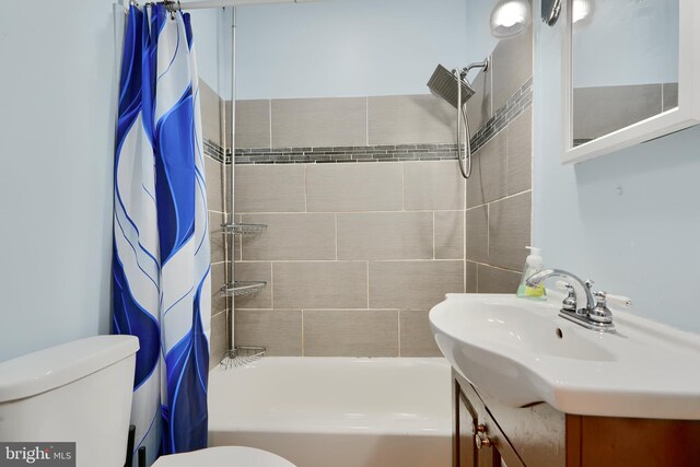 bathroom featuring toilet, shower / tub combo with curtain, and vanity